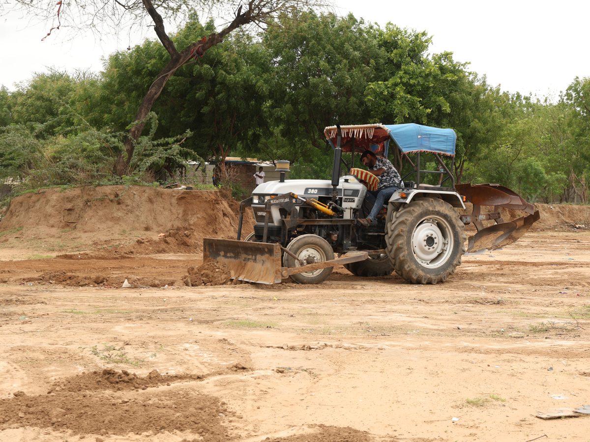 A tractor levelling and grading the prepared ground at Lapkaman